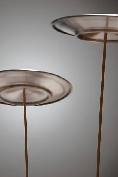 Spinning plates balanced on thin poles